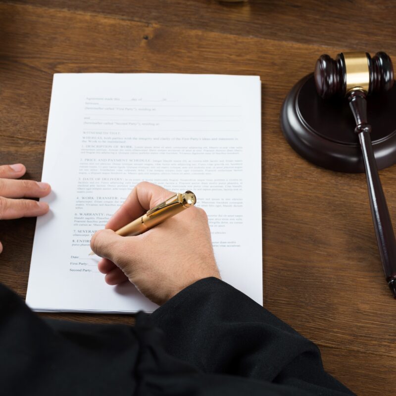 judge-writing-on-legal-documents-in-courtroom